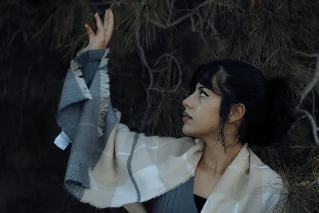 a person wearing a plaid scarf raising their hand for free reversible scarf knitting patterns