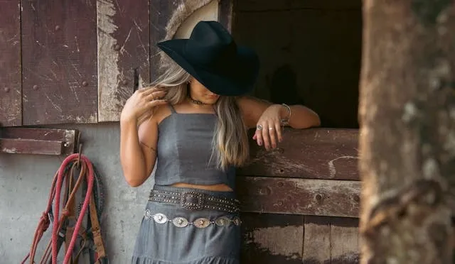a cowgirl in a rustic setting for what are belt buckles made of