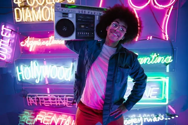 a person carrying a boom box in front of neon signs for 80s theme birthday party