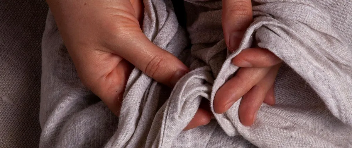 Hands pinching and pleating fabric into even gathered folds while swagging a tablecloth overlay for an event table.jpg Hands pinching and pleating fabric into even gathered folds while swagging a tablecloth overlay for an event table.jpg