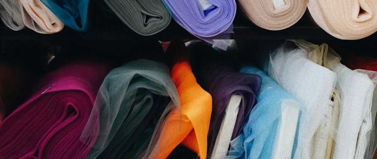 Rolled fabric bolts including satin and polyester textiles stacked on warehouse shelves for tablecloth swag storage between events.jpg Rolled fabric bolts including satin and polyester textiles stacked on warehouse shelves for tablecloth swag storage between events.jpg