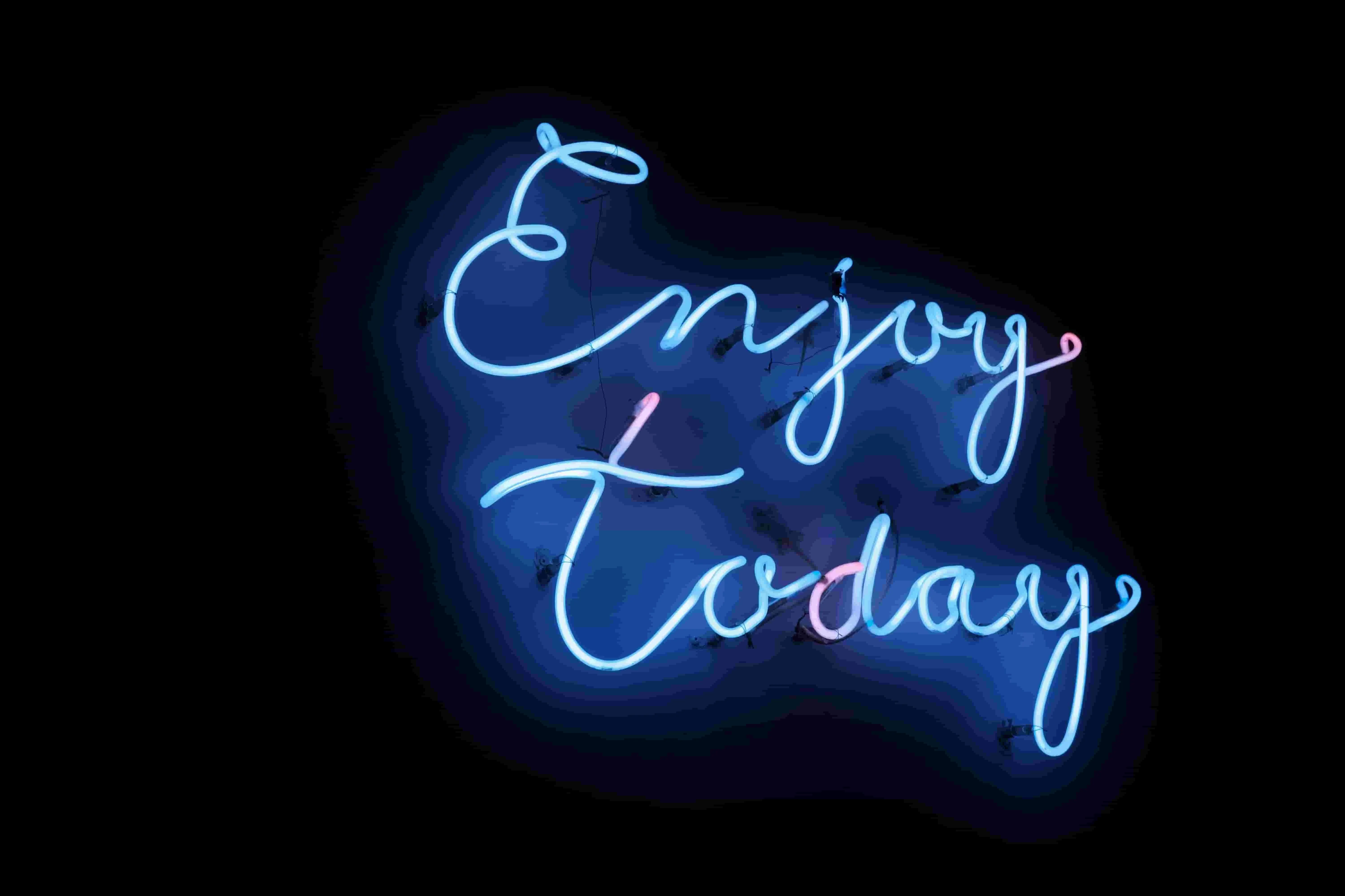 a blue neon sign that reads enjoy today for gas in neon lights