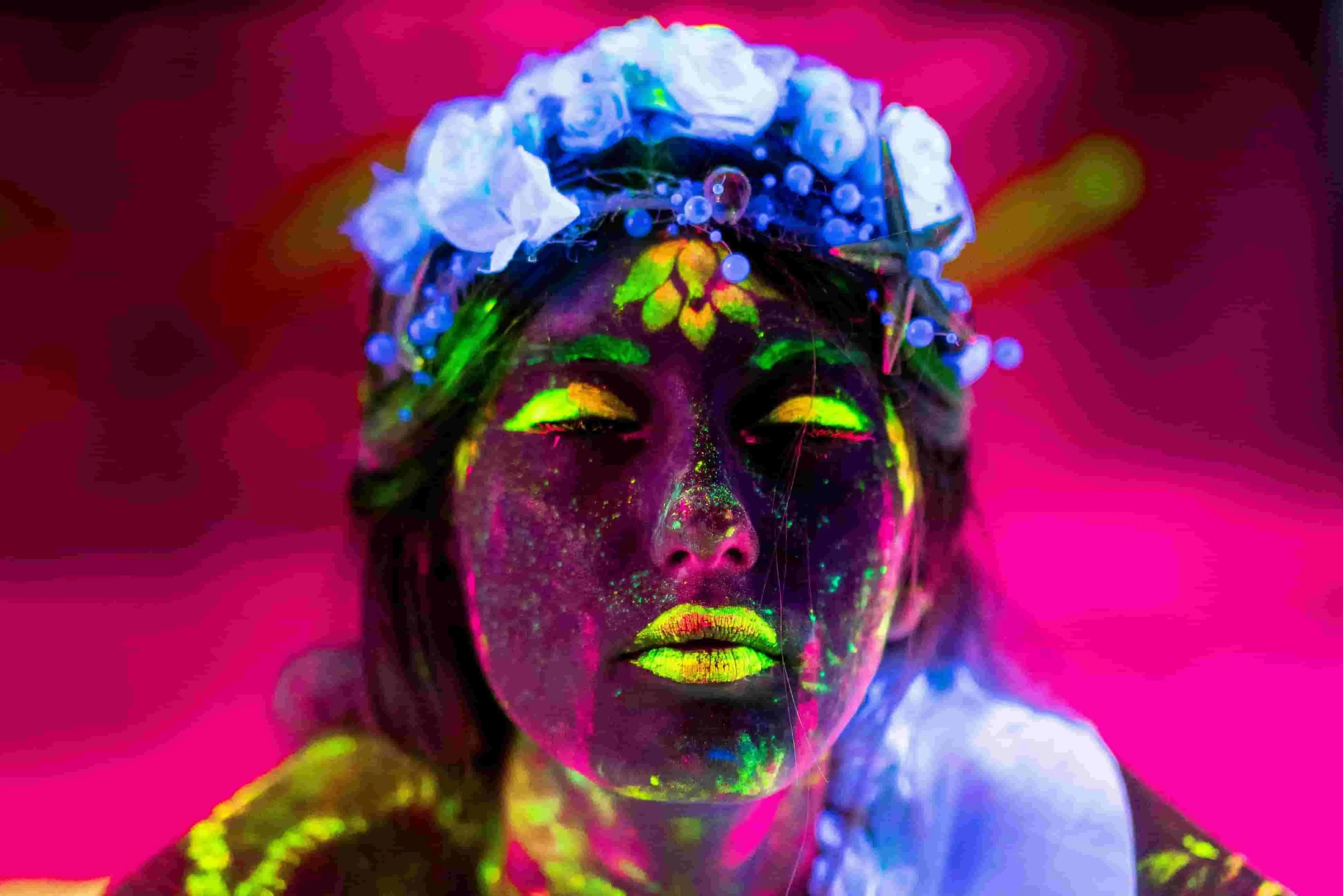 a woman wearing glowing fluorescent face paint under blacklight for does neon glow in the dark