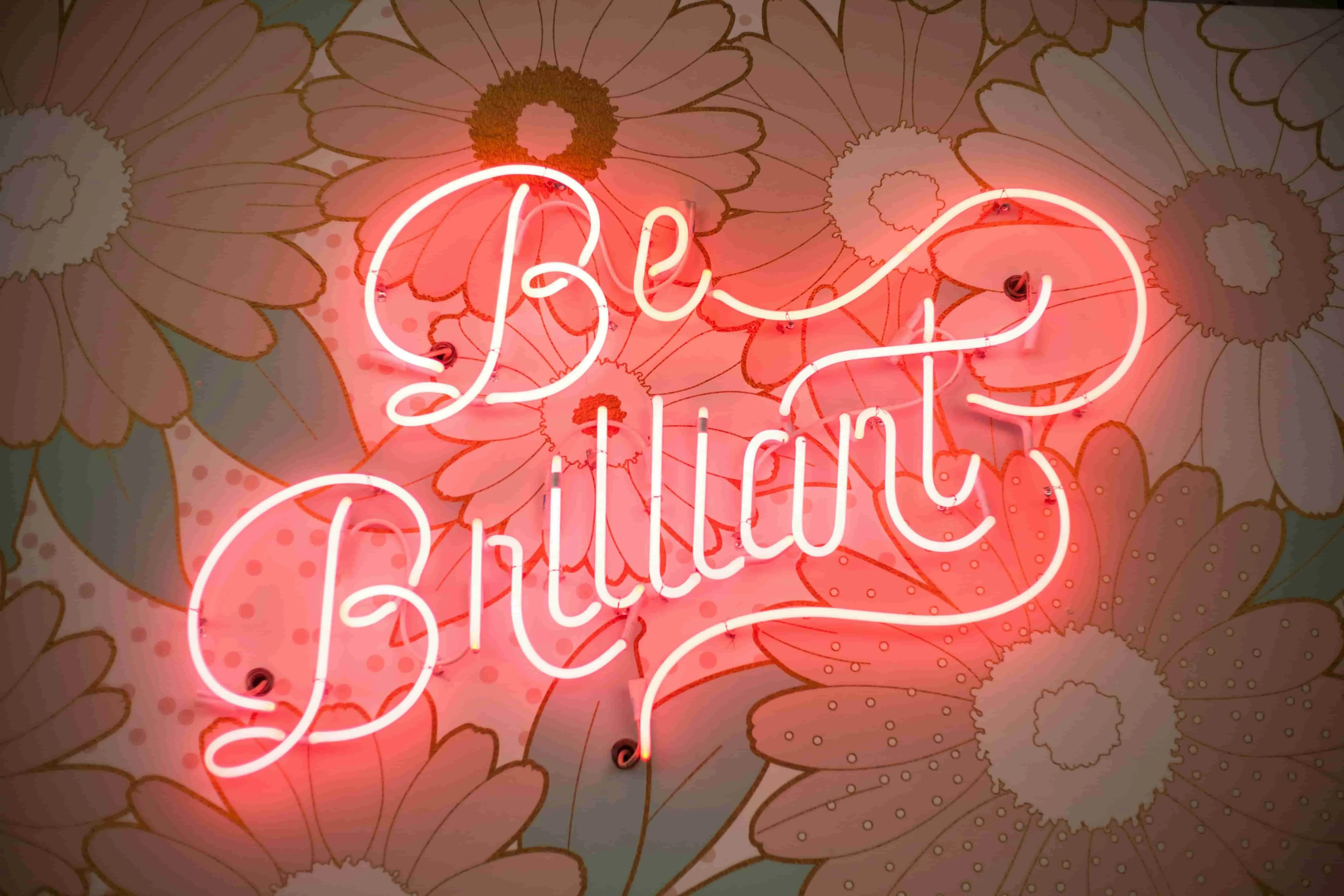a red neon sign that reads be brilliant for gas in neon lights