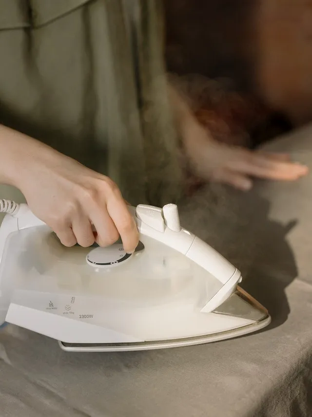 An iron being used on fabric for how to iron a tablecloth