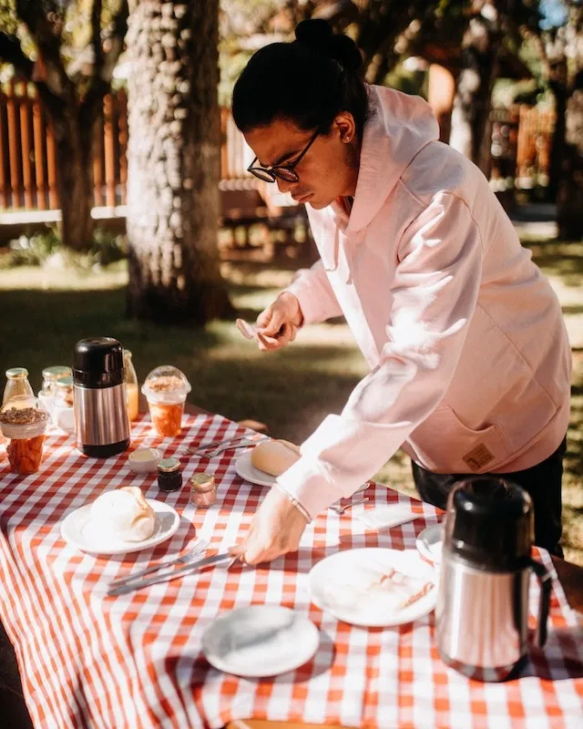 Man preparing a table with a tablecloth outdoors for how to keep tablecloths from blowing away