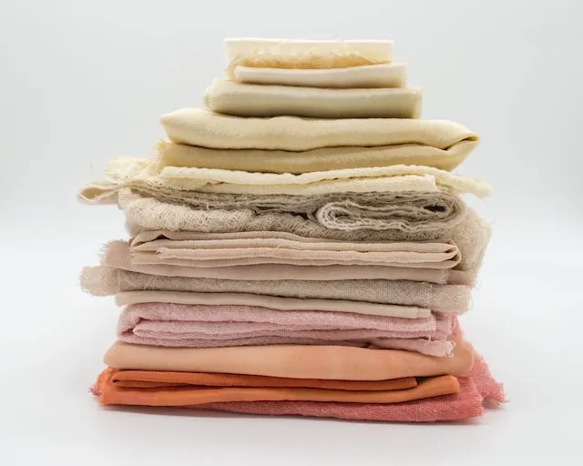 a pile of folded textiles for how to transport tablecloths without wrinkling