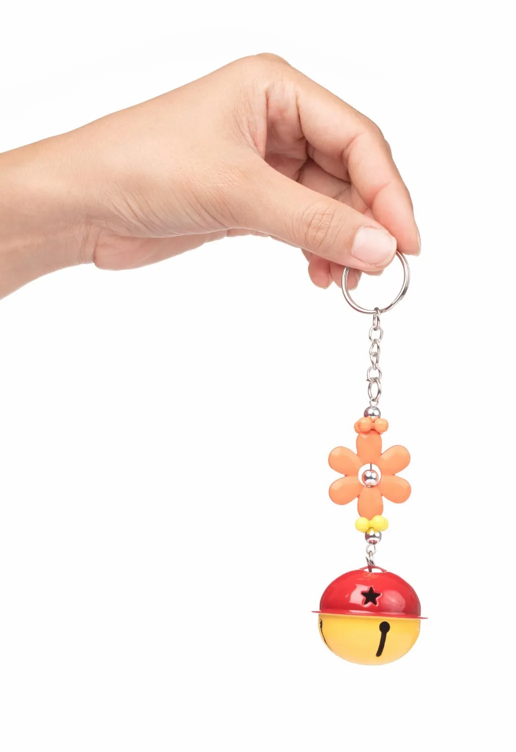 Hand holding diy keychain of bell with flower