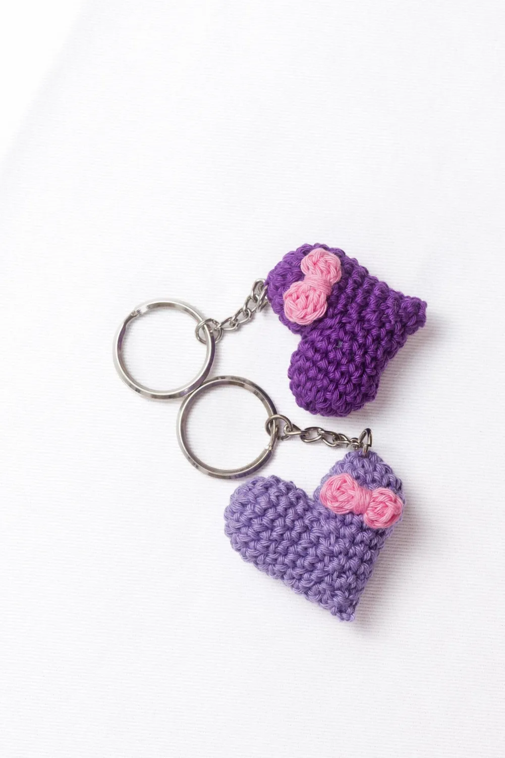 Crocheted purple heartshaped keyrings on a white background