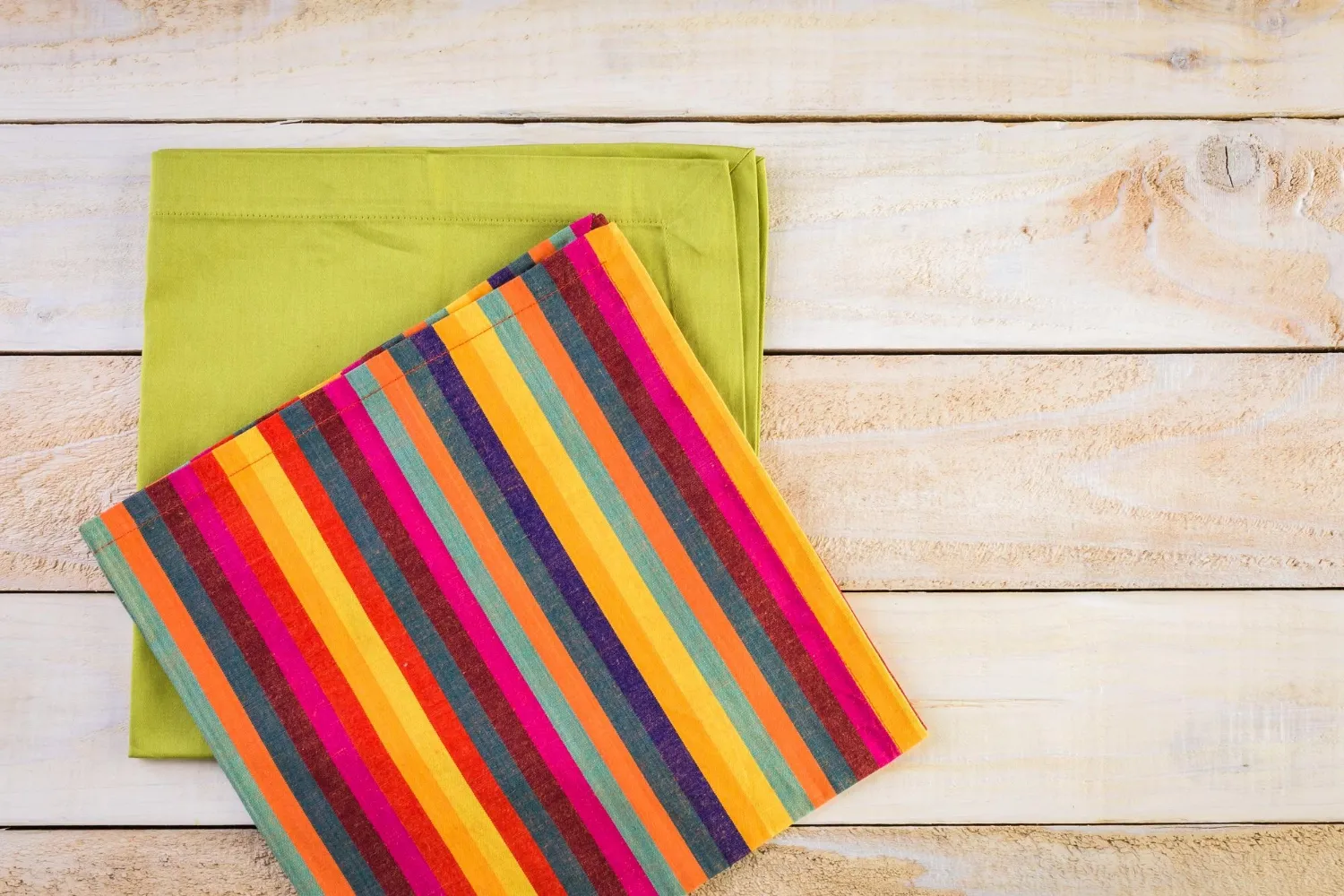 Colorful dinner napkins on a wood background