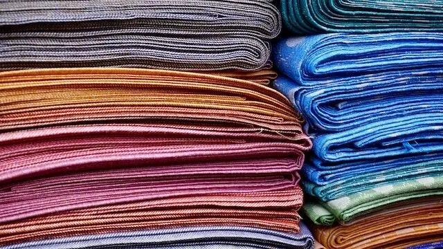 stacks of colored fabrics for best fabric for tablecloth