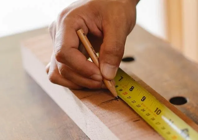 someone using tape measure for how to measure for a tablecloth