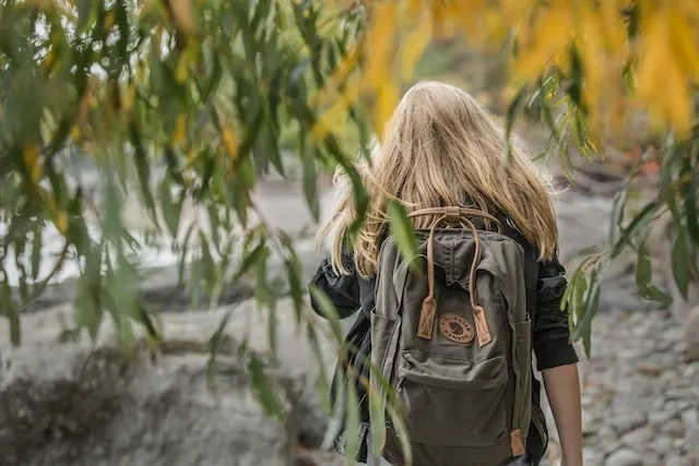 a woman wearing a backpack for how to iron on a patch to a backpack