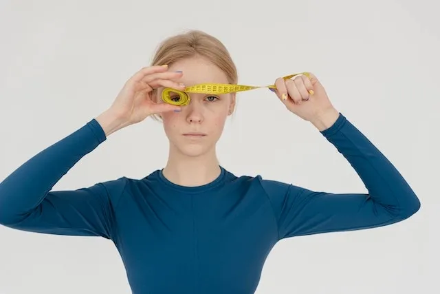 a woman with measuring tape for tablecloth square sizes