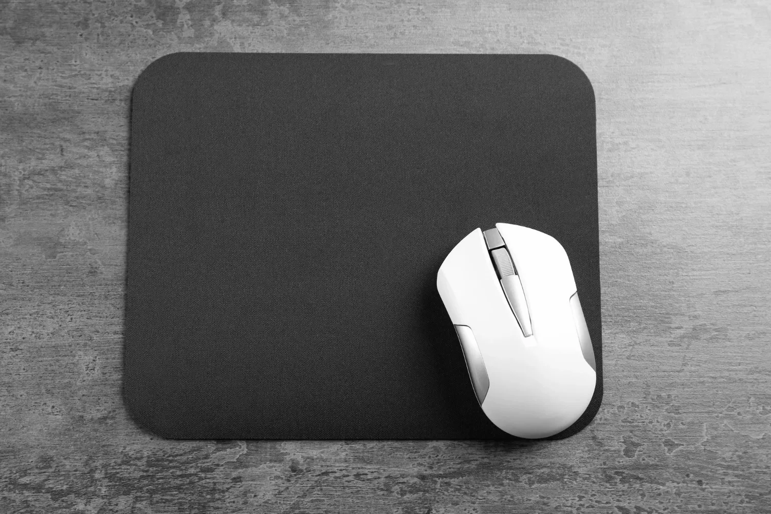 Blank mat and wireless mouse on textured background