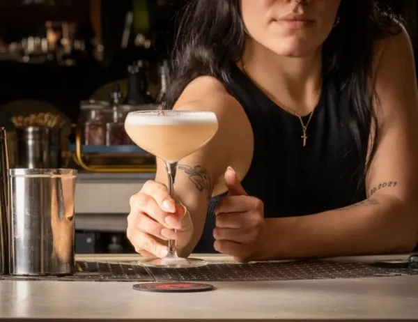 a woman serving at a bar for what are beer mats made from
