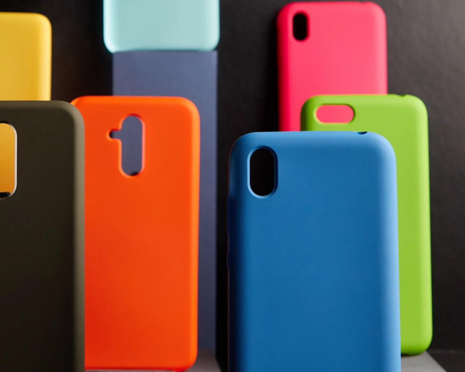 Colorful cases for modern smartphones stand on stands on the table one object