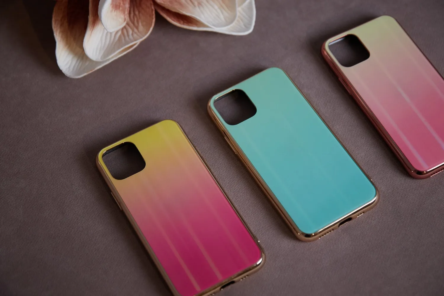 Beautiful women's mobile phone cases on the background of artificial flowers shimmer with a gradient shine