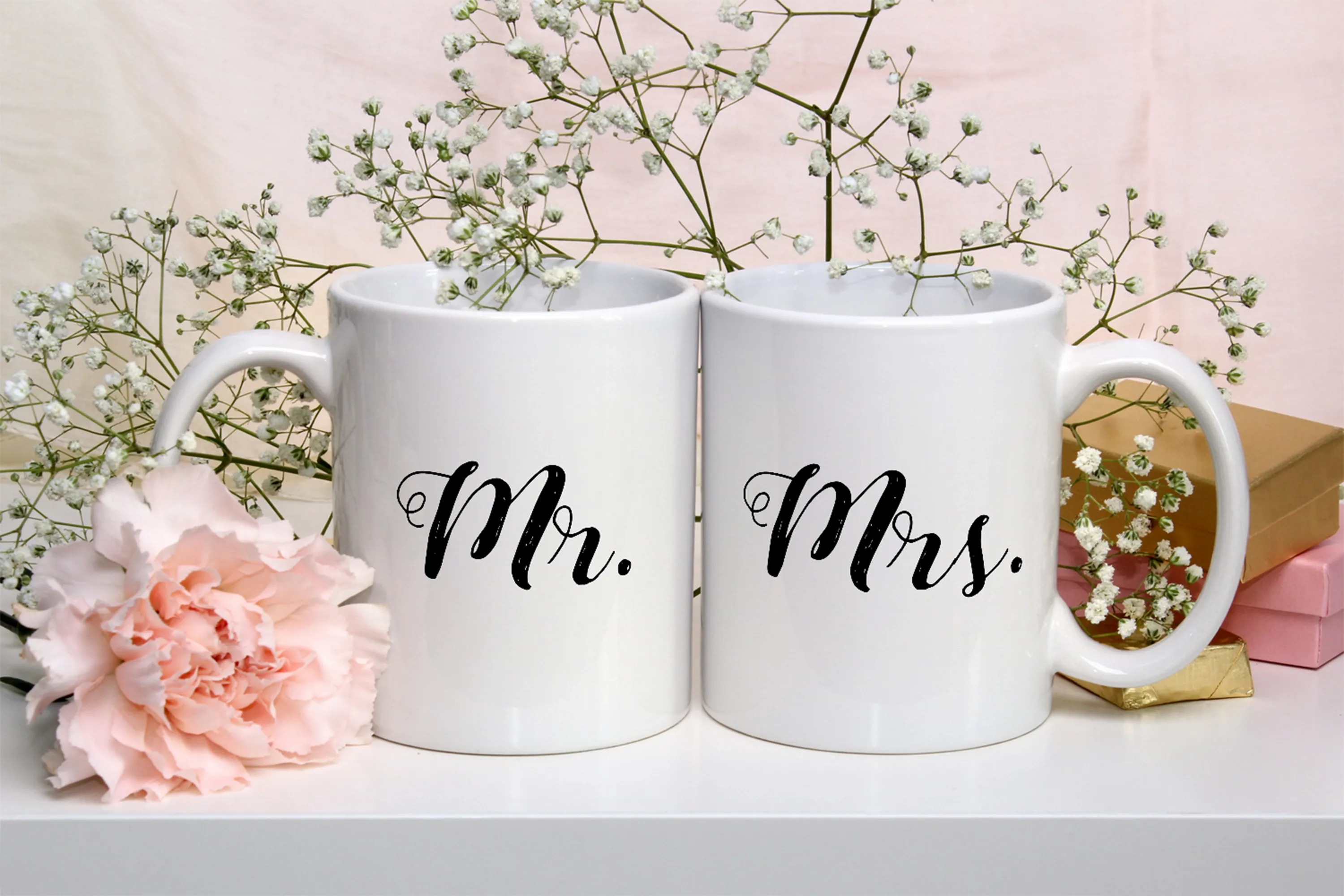 Mockup of two white coffee mugs with flowers