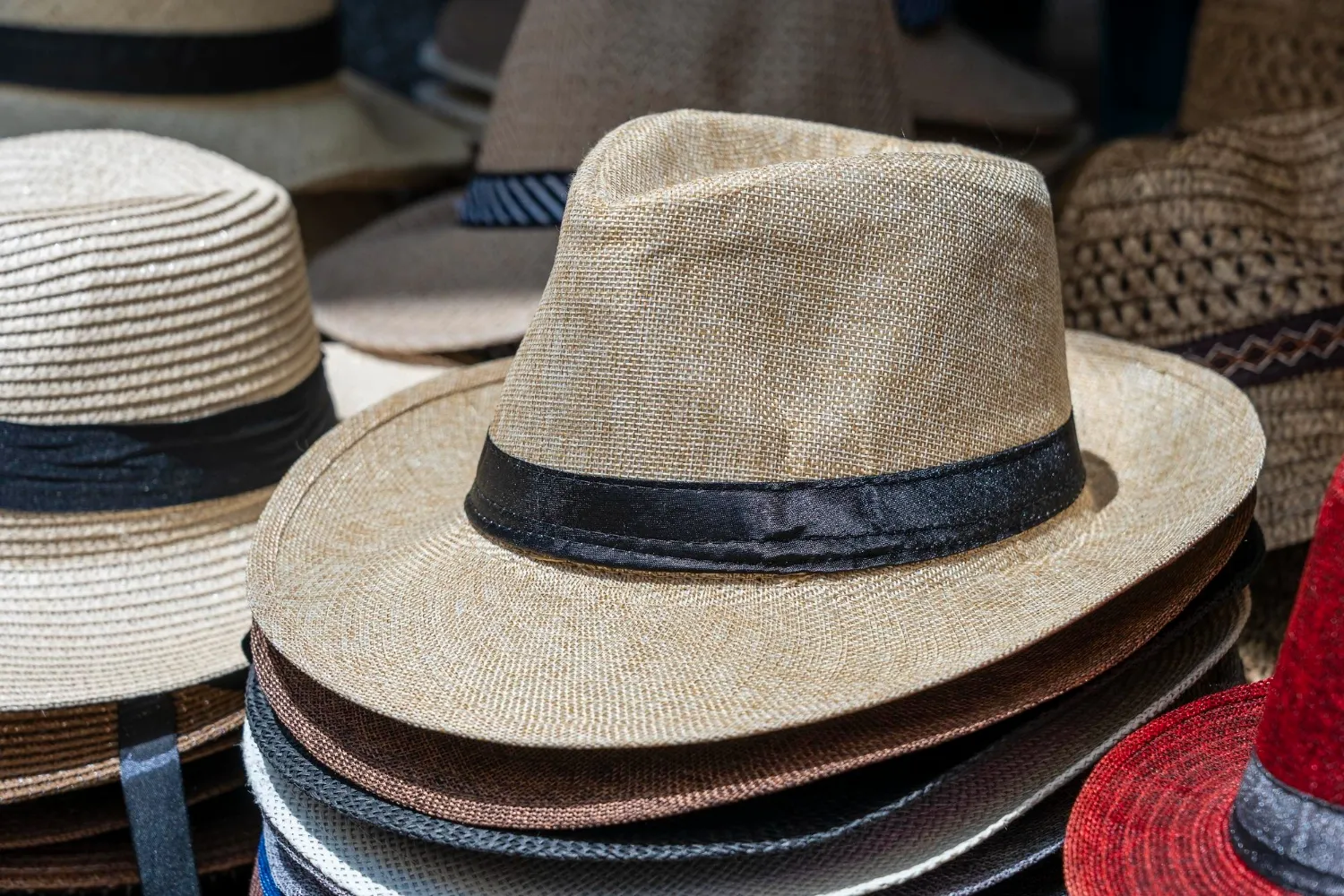 Straw hats on display for sale to tourists on street local market in ubud island bali indonesia closeup