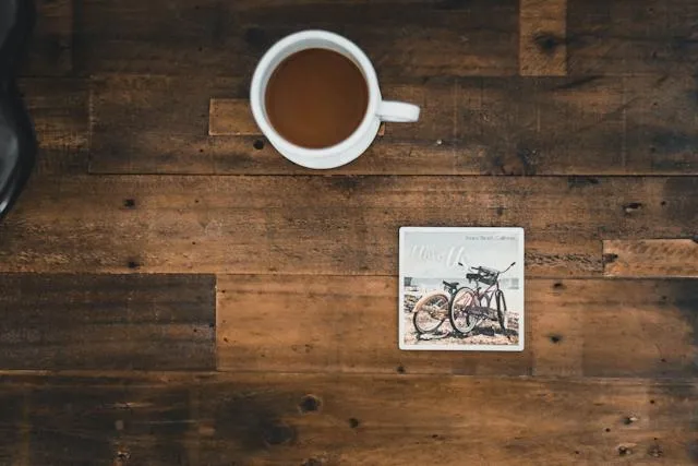 a cup of coffee and a coaster on a wood surface for best coffee warmer coaster