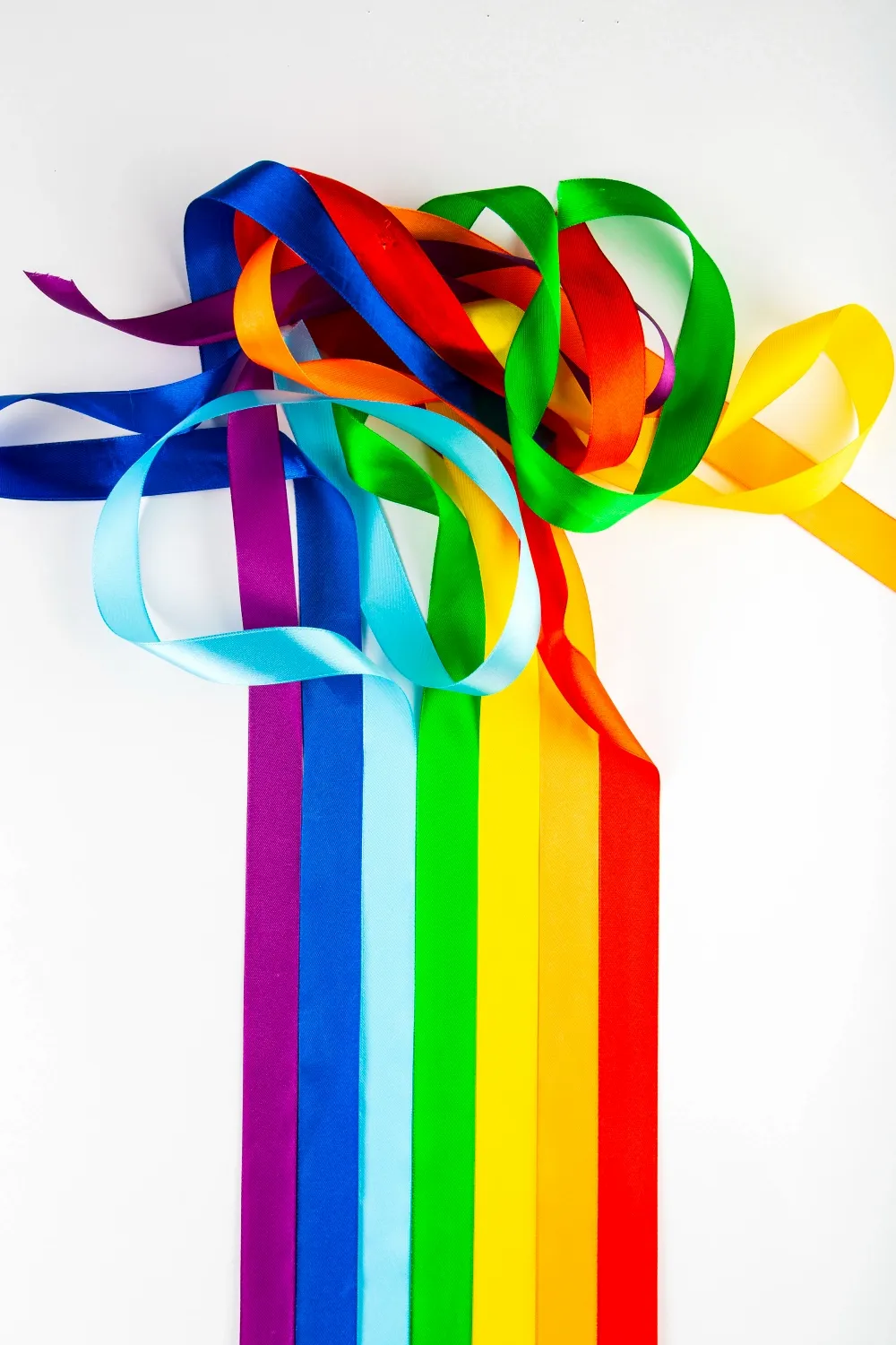 Lgbt flag symbol made of satin ribbons on a white background