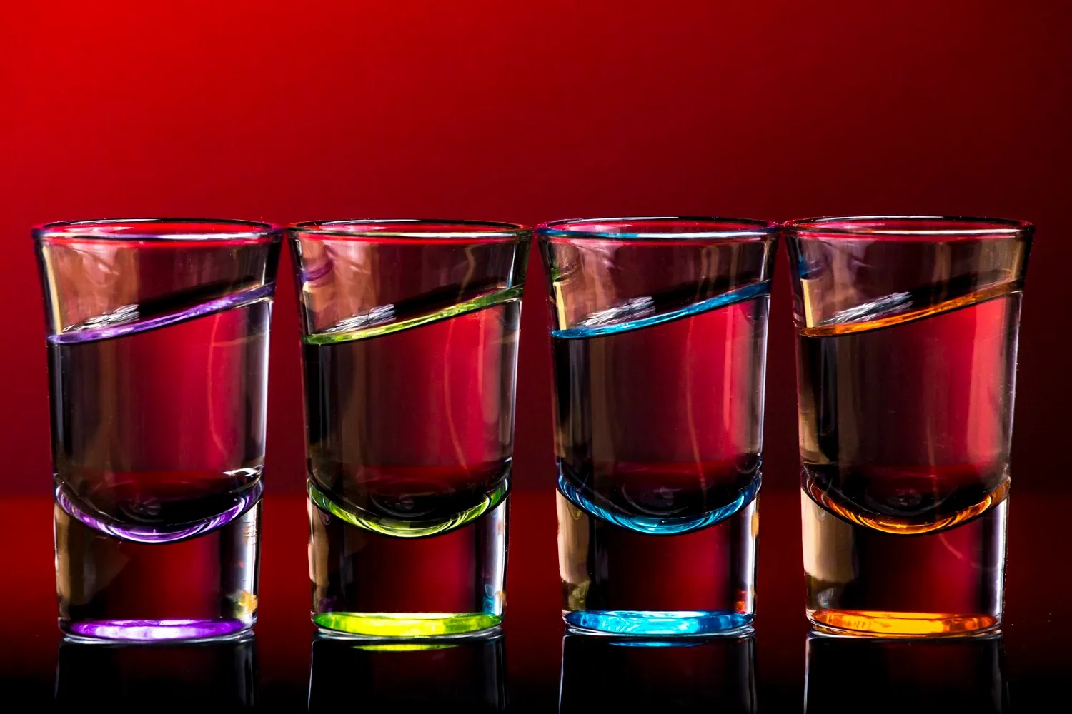 Shot glasses arranged side by side on table