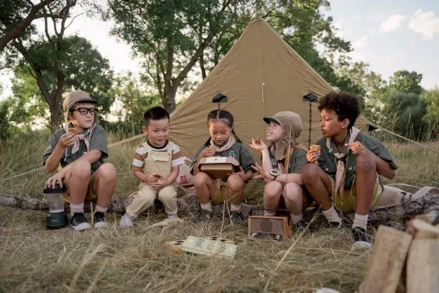 a group of young scouts by a tent for how to sew on boy scout patches