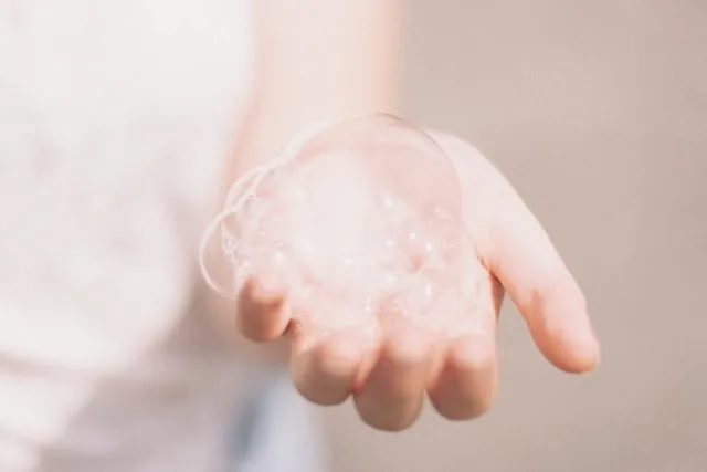 a hand with soap suds for how to clean bar mats