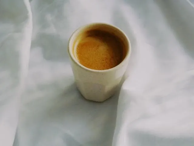 a cup of coffee on a white tablecloth for how to get coffee stain out of tablecloth