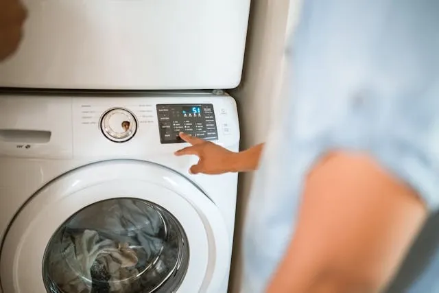 a person setting a washing machine for do iron on patches come off in the wash