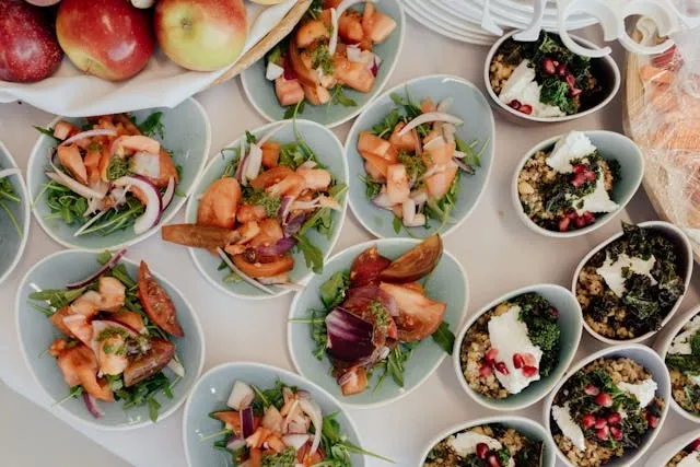 a selection of serving bowls on a table with food in them for catering checklist