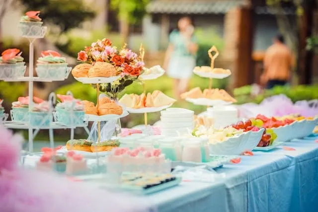 a table with a selection of cakes in an outdoor setting for catering checklist