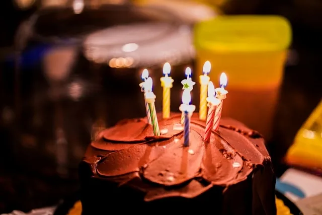 a chocolate birthday cake with candles for party supplies list