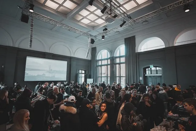 an audience gathered in front of a projector screen for corporate event planning checklist