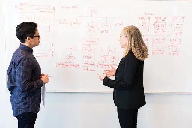 two people creating a marketing plan on a whiteboard for event planner marketing