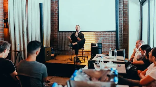 people sat around a stage listening to a speaker for event budgeting