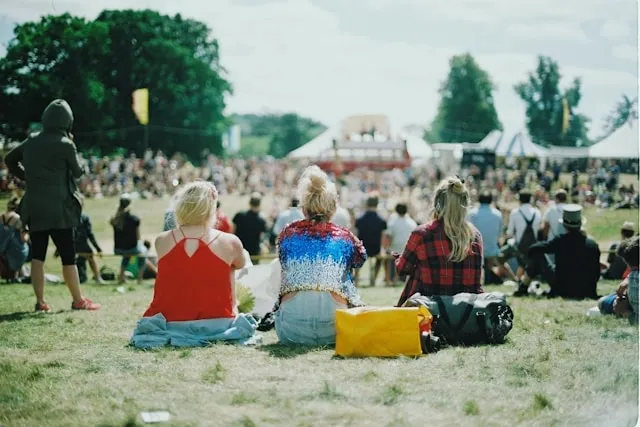 people sitting on the grass at a festival for outdoor event planning