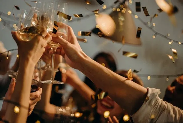 a group of people raising a toast with wine glasses for office party themes