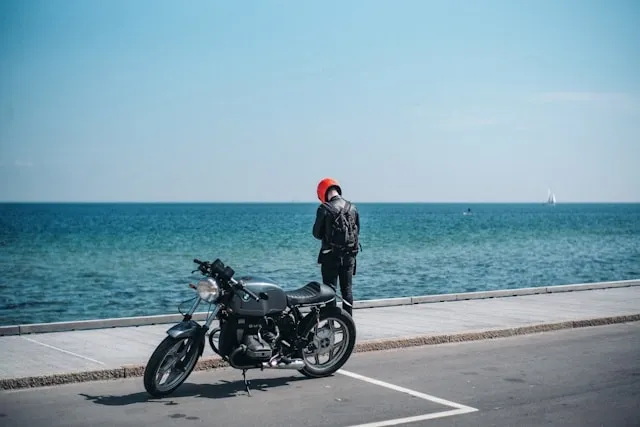 a motorcycle parked by the sea with the rider stood beside it for gifts for motorcycle riders