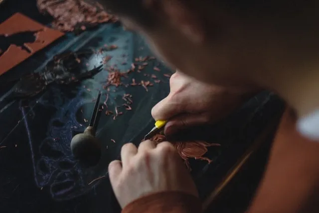 a person cutting and carving leather for how to make leather patches for hats