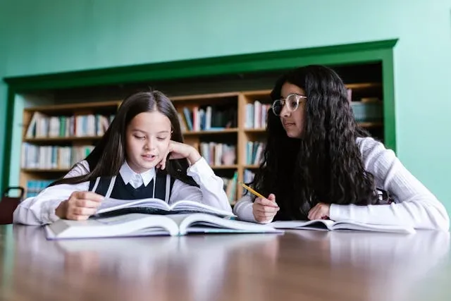 two young people studying at a desk for how to make your uniform look cute