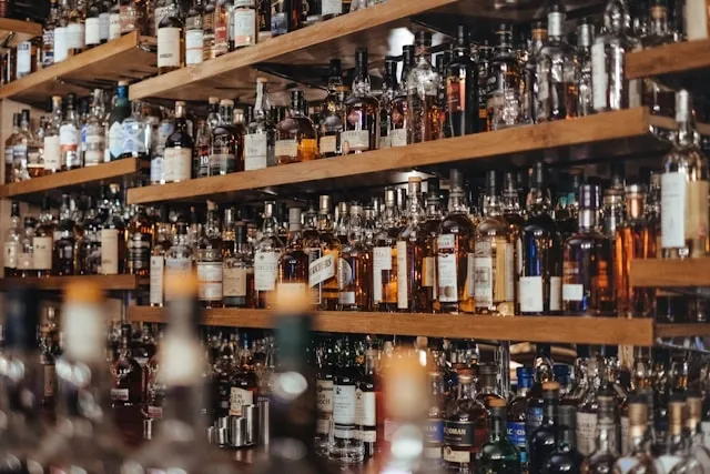 floating shelves filled with liquor for alcohol storage ideas