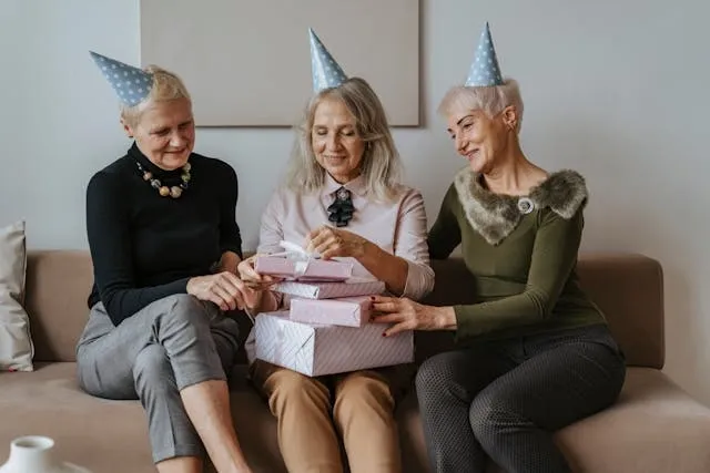 three people sitting on a sofa opening gifts for birthday party checklist for adults