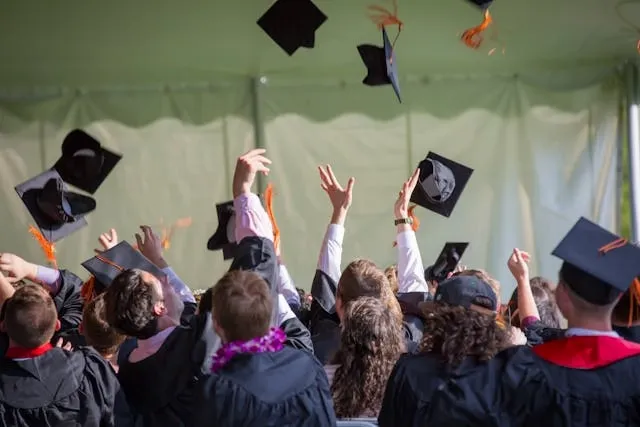 a photograph of young people at a graduation ceremony for diy graduation backdrop ideas