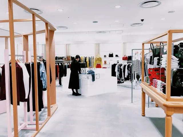 a person stood beside a display in a clothing store for how to improve customer experience in retail stores