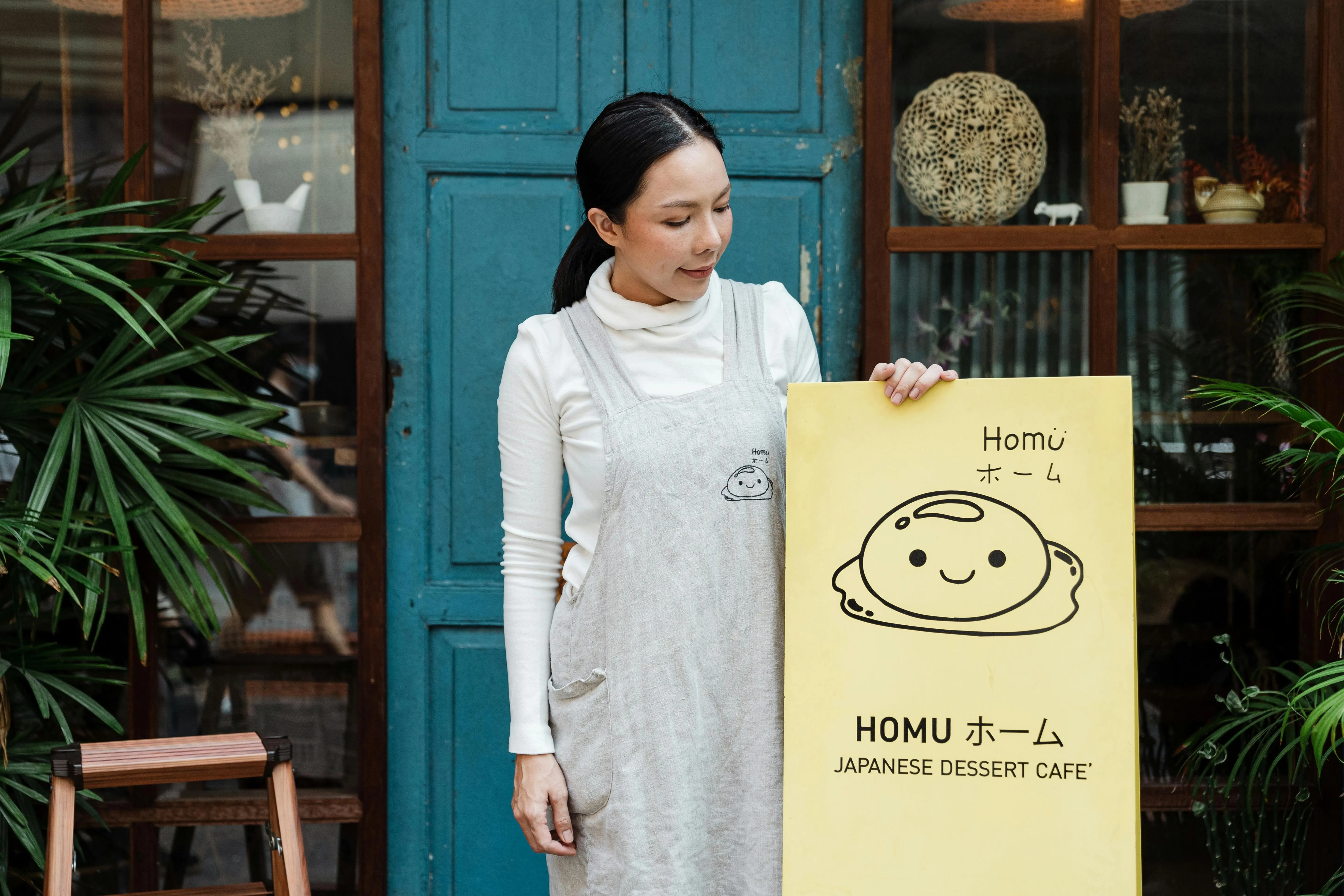 a person standing outside a restaurant holding their brand sign for restaurant branding ideas