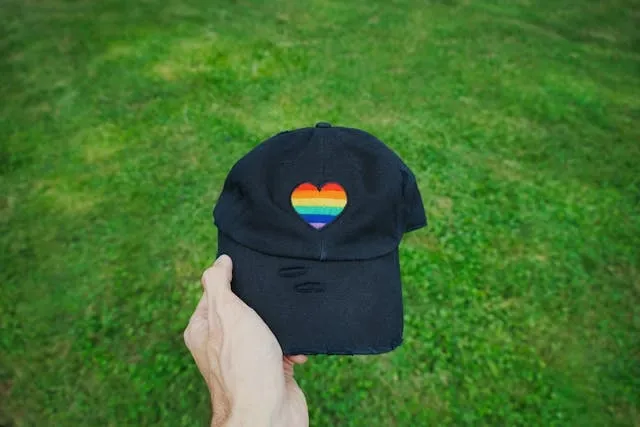 a black hat with a rainbow heart patch for how to iron a patch onto a hat