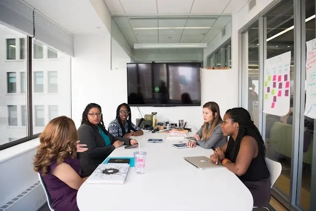 people having a meeting around a table for conference room lighting