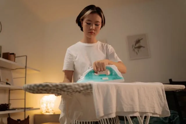 a person holding an iron on a garment for can you sew iron-on patches